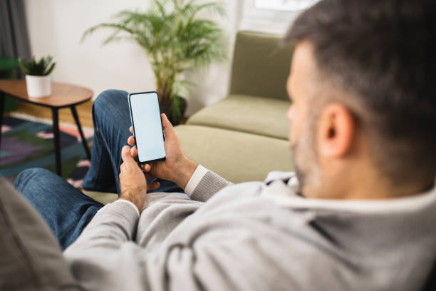 istock Man relaxing at home and using smartphone 1368843678