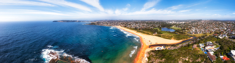 Pacific ocean coast of Sydney Northern beaches - aerial landscape panorama of Curl Curl beach and lagoon and suburbs.