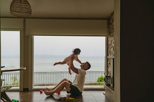 Photo of father and his baby girl spending precious moments together in their sea house