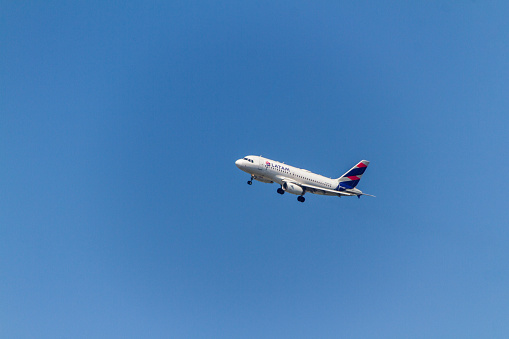 Airplane of LATAM Airlines company in Rio de Janeiro, Brazil - January 20, 2022: Airplane of Brazilian airline Latam, Flying with a beautiful blue sky over Rio de Janeiro.