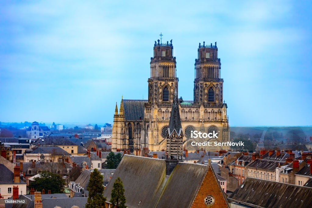 Cathedral Sainte Croix, downtown roofs in Orleans Cathedrale Sainte-Croix d'Orleans at evening dusk over downtown roofs Orleans - France Stock Photo
