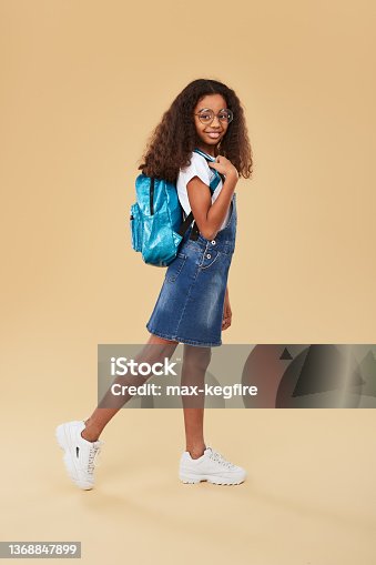 istock Cheerful black girl walking to studies 1368847899