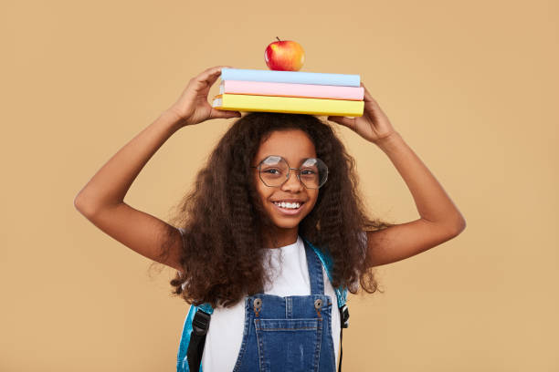 inteligentna czarna uczennica z podręcznikami i jabłkiem - pre adolescent child student isolated little girls zdjęcia i obrazy z banku zdjęć