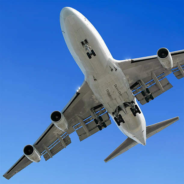 istock jumbo jet airplane landing in clear blue sky 136884978