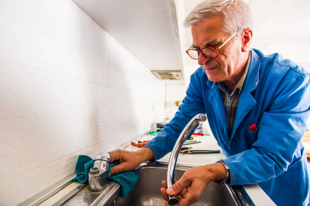 istock Senior handyman fixing kitchen faucet 1368851836