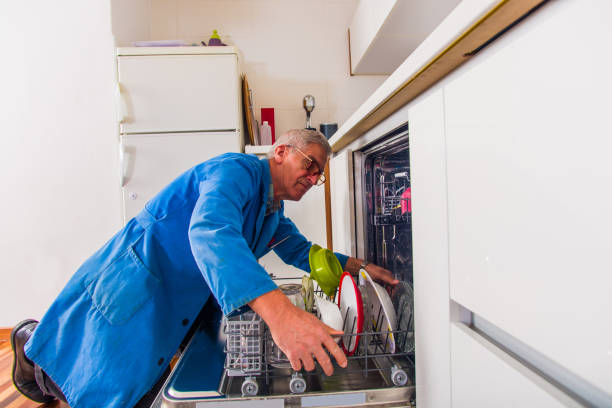 istock Old age workman is opening the dishwashers with a bunch of tools near him 1368851887