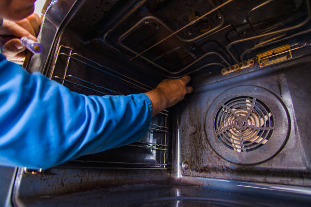 istock Old age laborer fixing the oven in kitchen 1368851956