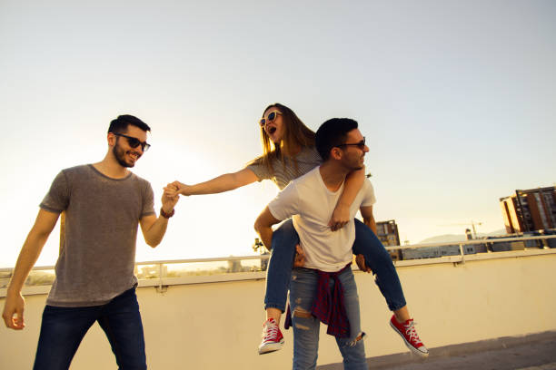 istock Group of young people having fun at a rooftop on sunset 1368853311