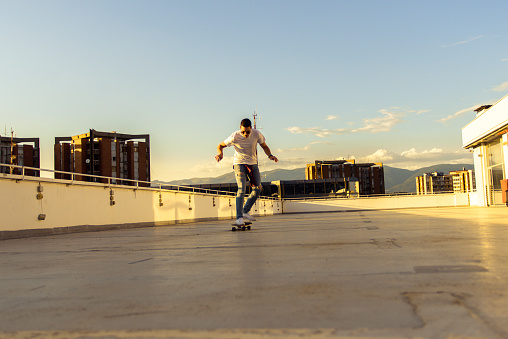 Urban boy having fun and driving skateboard on the balcony