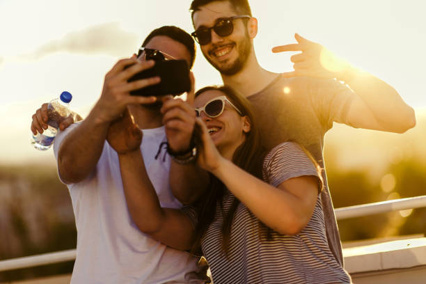 istock Best friends taking selfie outdoors with back lighting 1368853475