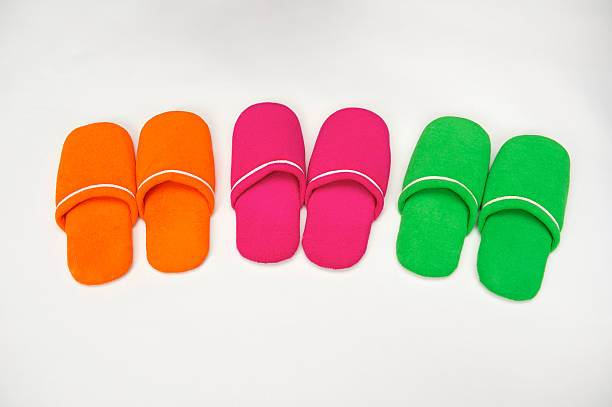 Three pairs of brightly coloured bathroom slippers