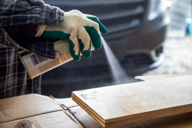 Gloved Hand Spraying on Finish Gloved hand spraying shellac on wood board aerosol can stock pictures, royalty-free photos & images