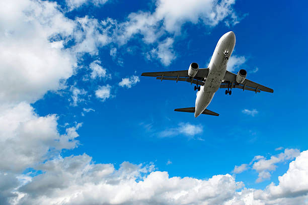 avião a jato pousando no céu brilhante - airplane taking off sky commercial airplane imagens e fotografias de stock