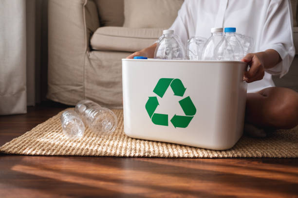 istock A woman collecting and separating recyclable garbage plastic bottles into a trash bin at home 1368871857