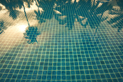 a glass of clean drinking water near the pool on a hot day. Summer vacation concept