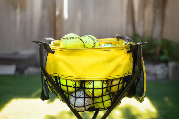 ball caddy with softballs in backyard or park, setup for training. - catching horizontal nobody baseballs imagens e fotografias de stock