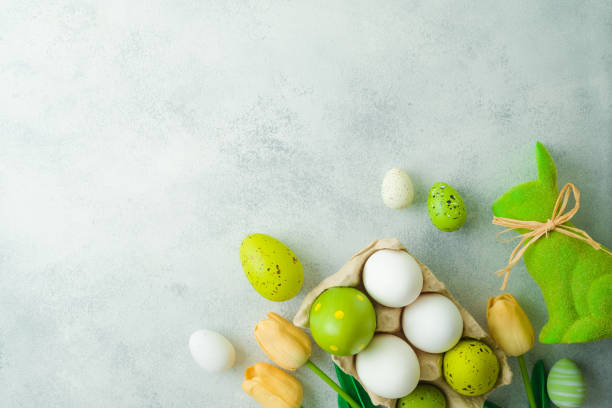 istock Easter holiday concept with Easter eggs and tulip flowers decor on gray background. Top view, flat lay 1368885458