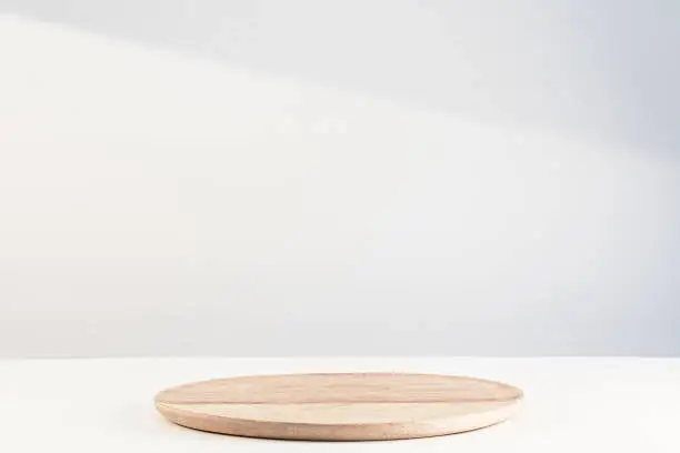 Photo of Wooden dish on white. Food or product podium