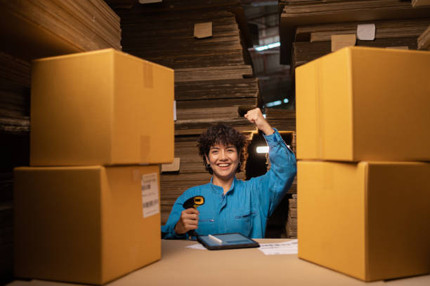 People working in storage, taking parcel and scanning barcode, putting box on shelf. Female business person at workplace in warehouse, concept of delivering and logistics. Businesswoman owner.