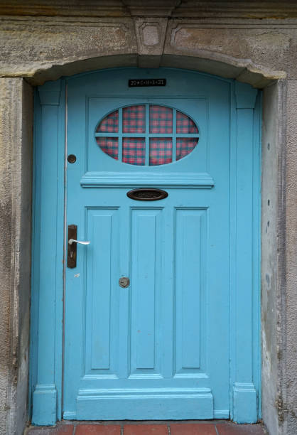 An old fashioned light blue door with glass panels and a plate with chalk where 20*C+M+B+21 is written on.  CMB is an abbreviation of the Latin words Christus mansionem benedicat (Christ bless this house). 2021 stands for the year. The inscription is meant to invoke a blessing upon the house and its inhabitants and protect them from misfortune. Seen in Bremen, Germany. In the old town part (Altstadt).
