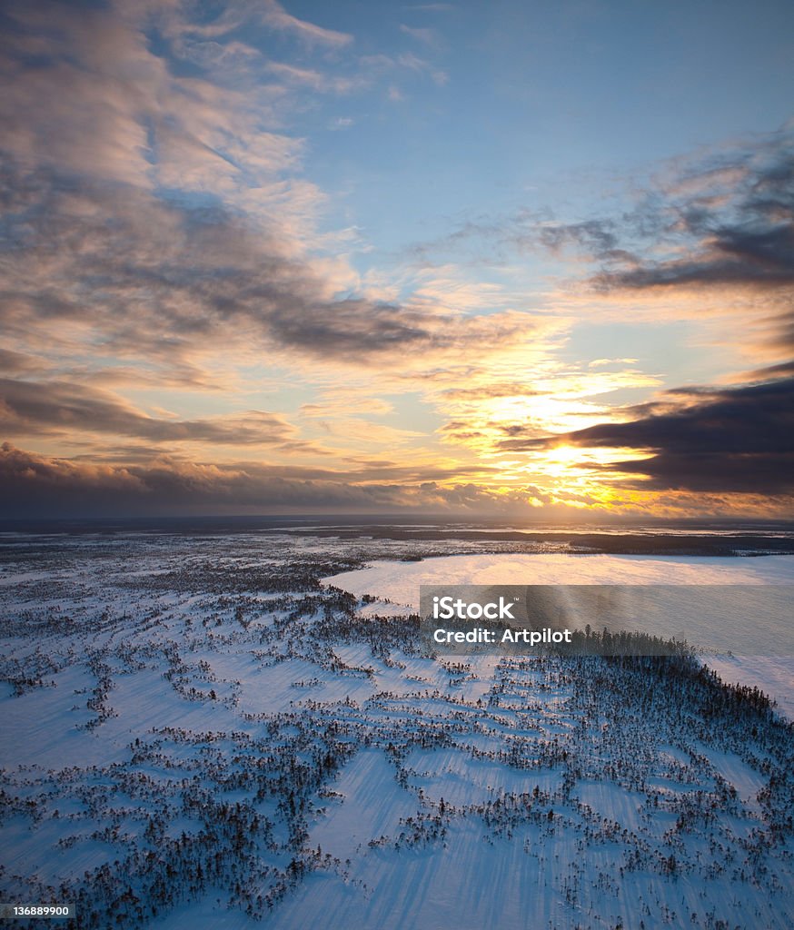 Sunset above frozen lake Aerial view of winter landscape with frozen lake on the background of a sunset. Above Stock Photo