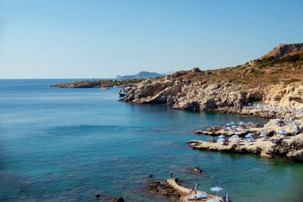 istock Sunbeds and umbrellas on rocky seashore 1368899474