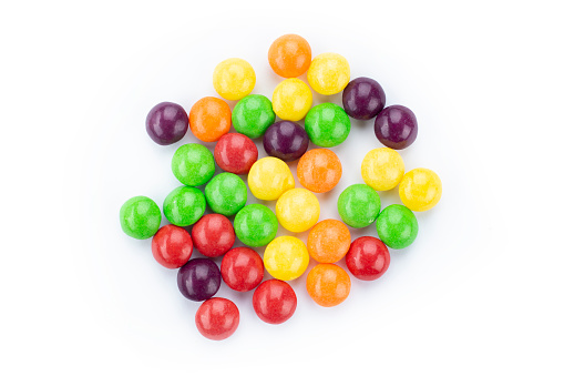 The multicolor flavored fruit candies on white background. Top view.