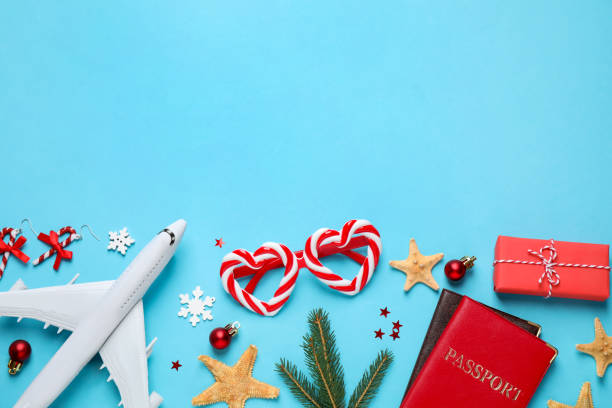 istock Flat lay composition with Christmas decorations and passports on light blue background, space for text. Winter vacation 1368903715