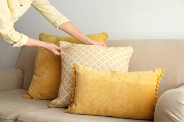 istock Woman arranging pillows on sofa, closeup view. Interior design 1368903828