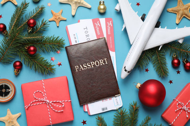 istock Flat lay composition with Christmas decorations, passport and airline tickets on blue background. Winter vacation 1368904745