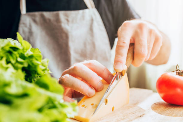istock A man cuts hard cheese into thin slices - prepares a delicious hearty breakfast 1368904966