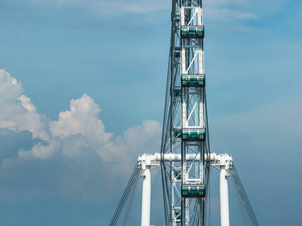 The Singapore Flyer Ferris Wheel seen during the day with a blue cloudy sky in the background. The Singapore Flyer Ferris Wheel is located in the middle of the city at Marina Bay.