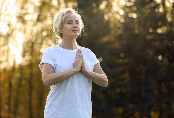 istock Mature woman practicing yoga outdoors in morning 1368905199