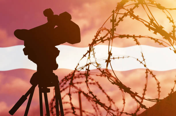 istock Double exposure - camera, barbed wire and flag Latvia 1368907093