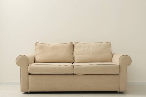 istock Comfortable sofa near beige wall in living room interior 1368908768