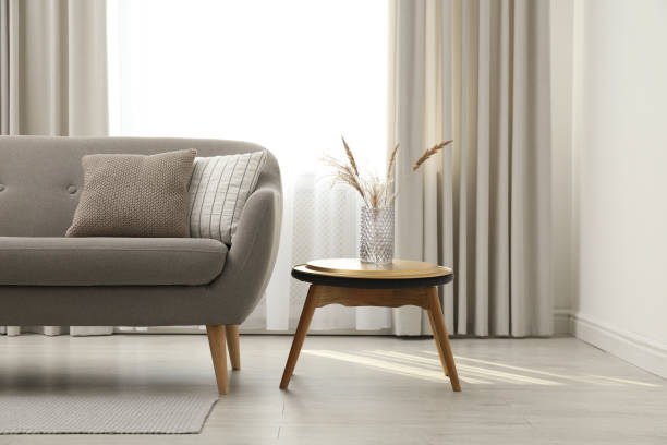 istock Grey sofa with pillows near window in stylish living room interior 1368909660