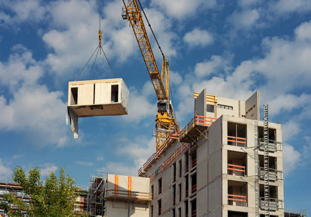 istock Crane lifting a wooden building module to its position in the structure. 1368909675