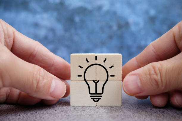 istock Hand stroking a light bulb on a wood block with Word Ideas, fresh idea concept with innovation and inspiration, revolutionary science and communication concept 1368910700