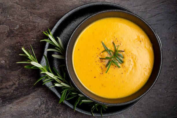 zuppa di zucca con tovagliolo di lino su sfondo scuro. - soup pumpkin soup vegetarian food food foto e immagini stock