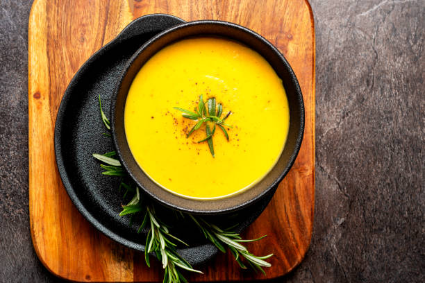 istock Pumpkin soup with linen napkin on dark background. 1368912261