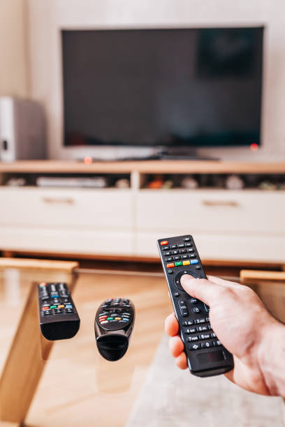 istock Male hand points remote control at tv - watching tv 1368912262
