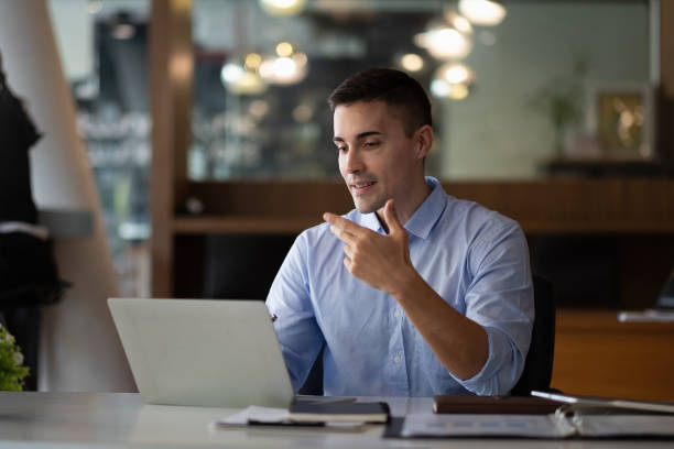 istock smiling businessman having virtual team meeting call, talking, remotely working at home watching online learning training webinar in remote office 1368913392