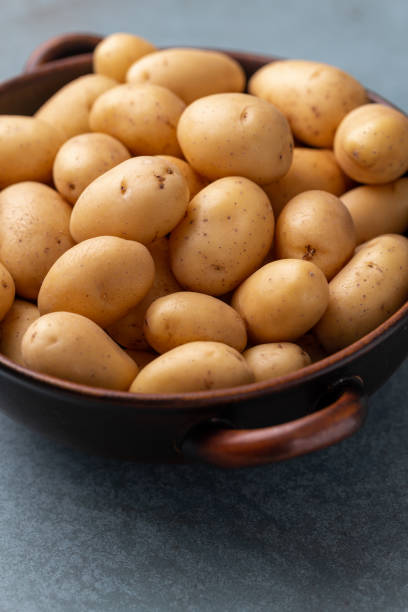 istock Raw small potatoes in a cast iron skillet on a beton background. 1368913467