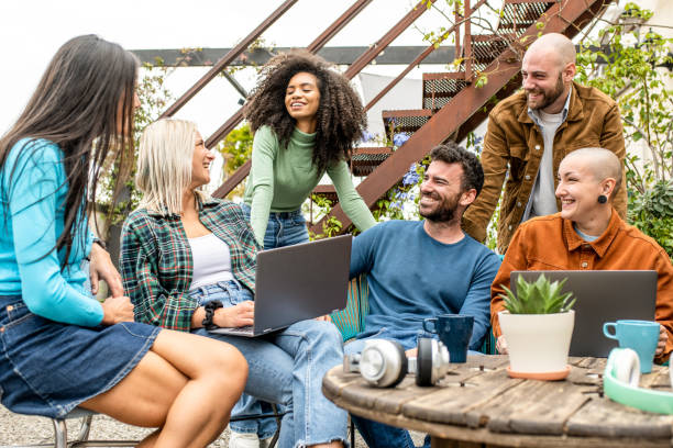 Digital native group of friends sharing content and ideas in team work meeting,  tech life style concept with guys and girls having fun, telecommuting an remote work place concepts, young creative