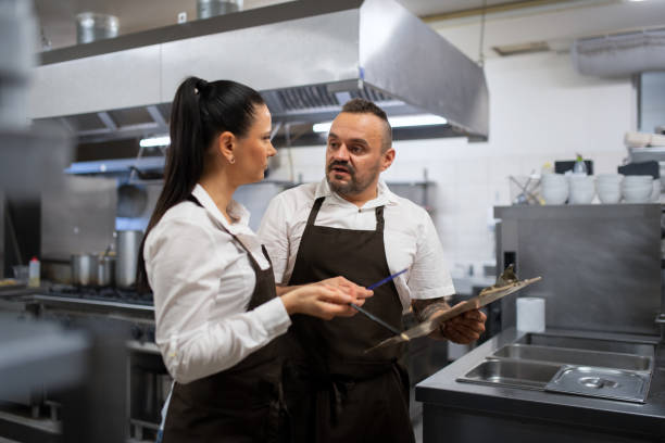istock Chef and cook discussing menu indoors in restaurant kitchen. 1368915608
