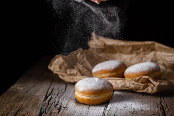 istock Donut filled with jam on black background, sprinkled with sugar. 1368916199