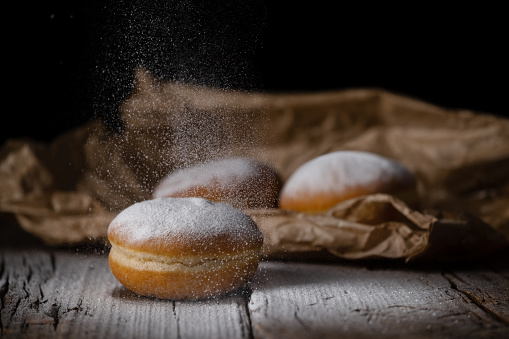 Berliner krapfen filled with marmalade sprinkled with white sugar. Traditional Mardi Gras or Fat Tuesday doughnut.