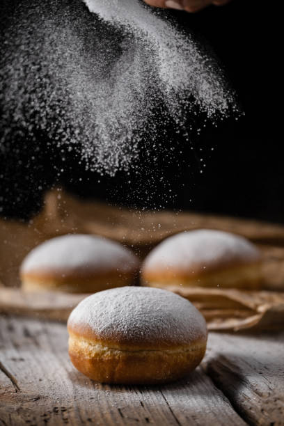 istock Donut filled with jam on black background, sprinkled with sugar. 1368916293