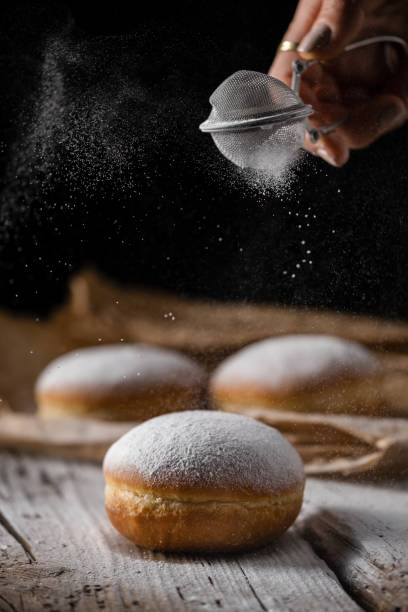 Berliner krapfen filled with marmalade sprinkled with white sugar. Traditional Mardi Gras or Fat Tuesday doughnut.
