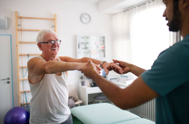 istock Young physiotherapist exercising with senior patient in a physic room. 1368917108